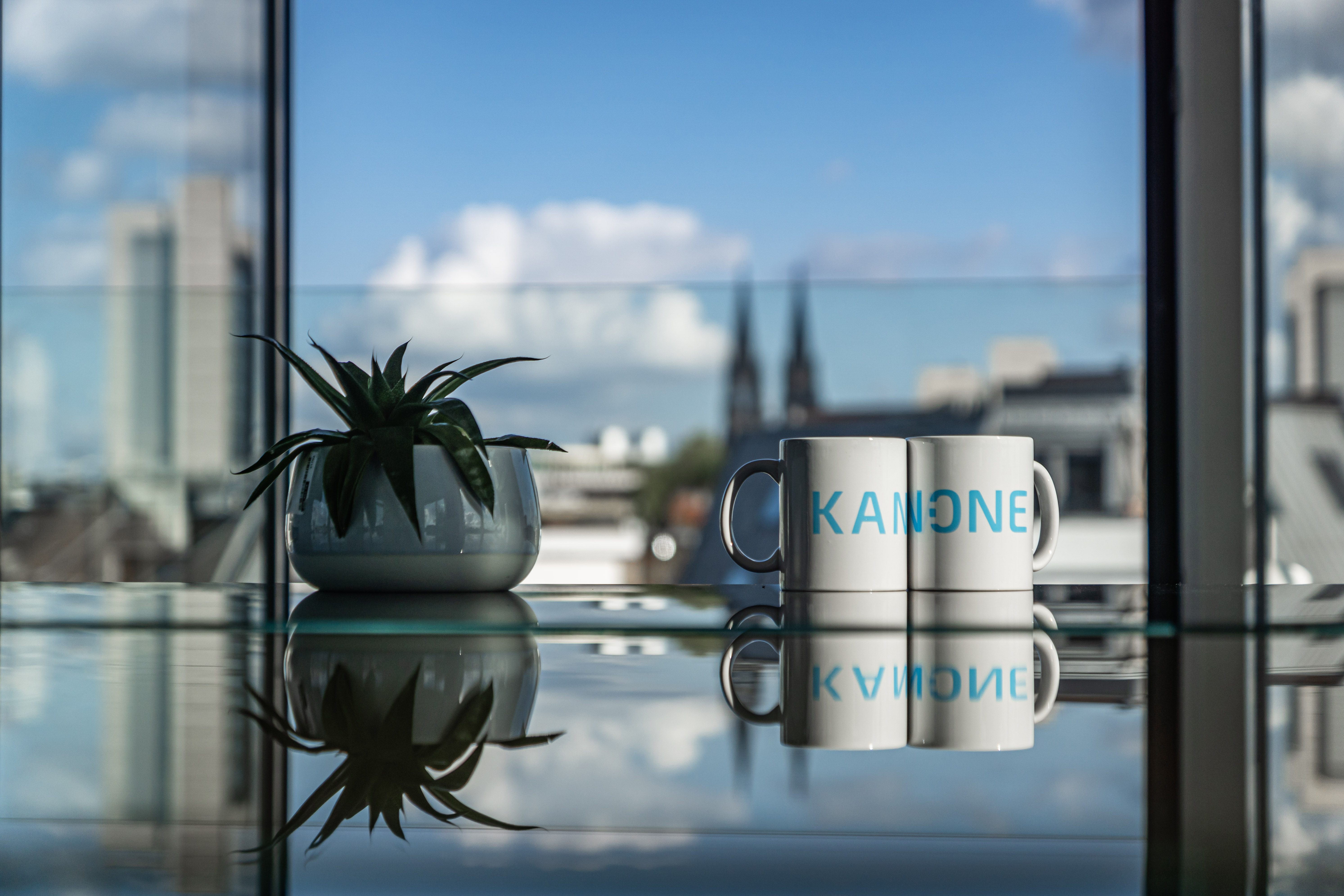 KAN-ONE Merch Tassen vor Kölner Dom im Hintergrund